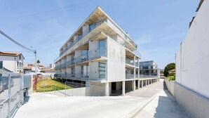 Un immeuble moderne à plusieurs étages, doté de balcons et de grandes fenêtres.