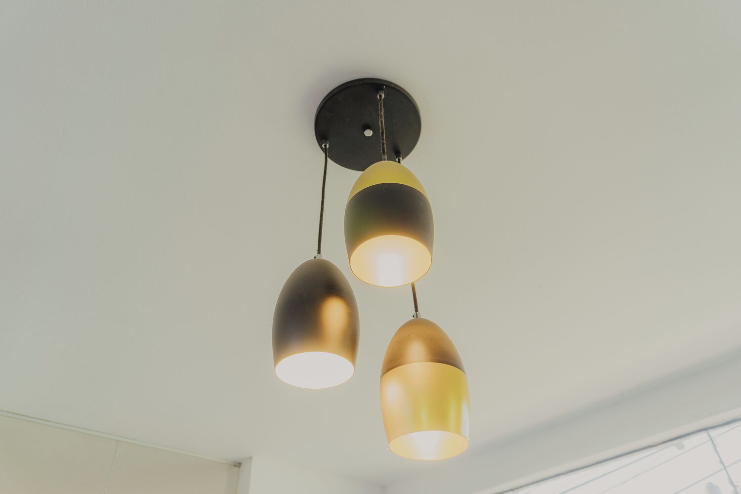 Una lampada a sospensione fissata al soffitto con tre lampadine.