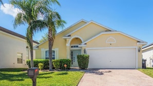 A single-story house with a garage, a mailbox, and a well-maintained lawn.