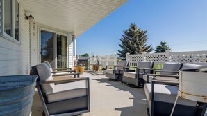 Une terrasse extérieure avec plusieurs chaises et un grand bac à fleurs.