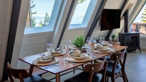 A dining table set for six with a view of the outdoors through skylights.