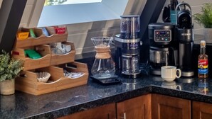 A kitchen with a skylight, coffee maker, and coffee pot.