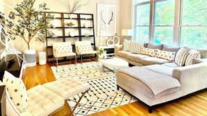 A modern living room with a sofa, chairs, a coffee table, and a bookshelf. - EXQUISITE, DESIGNER HOME, 4BD/2.5BA, 4 miles from MAYO CLINIC (Rochester)