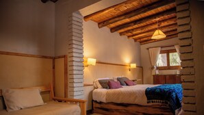 A cozy bedroom with a wooden bed, a smaller bed, and a nightstand. - San Ignacio Estancia Andina (Guaymallen)