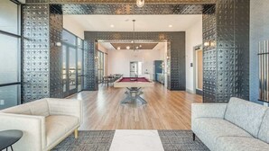 Un grand espace de vie comprenant une table de billard, deux canapés et un coin repas.
