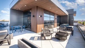 Une terrasse sur le toit, avec des sièges en plein air, de grandes fenêtres et une vue sur la ville.