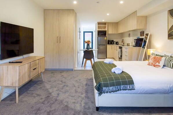 Une chambre d’hôtel équipée d’un lit, d’une télévision, d’un bureau et d’une kitchenette.