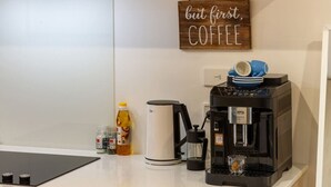 A kitchen counter with a coffee maker, a kettle, and a bottle of honey.