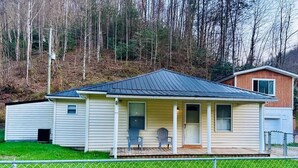 Ein eingeschossiges Haus mit Veranda, Garage und einem umzäunten Garten.