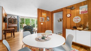 A dining area with a round table, chairs, and a buffet counter.