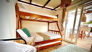 Una cama litera de madera con una alfombra estampada, una cesta tejida y una toalla blanca en el suelo.