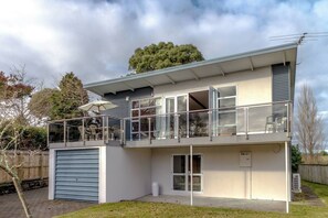 A two-story house with a balcony, a garage, and a small front yard. - Lakeside Delight with Mountain Views (Taupō)