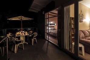 An outdoor dining area with a table and chairs, a large umbrella, and candles. - Lakeside Delight with Mountain Views (Taupō)