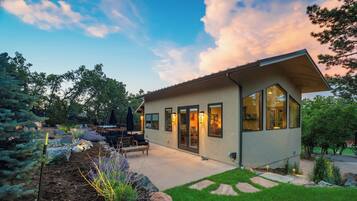 A modern house with a patio, outdoor seating, and a well-maintained garden.