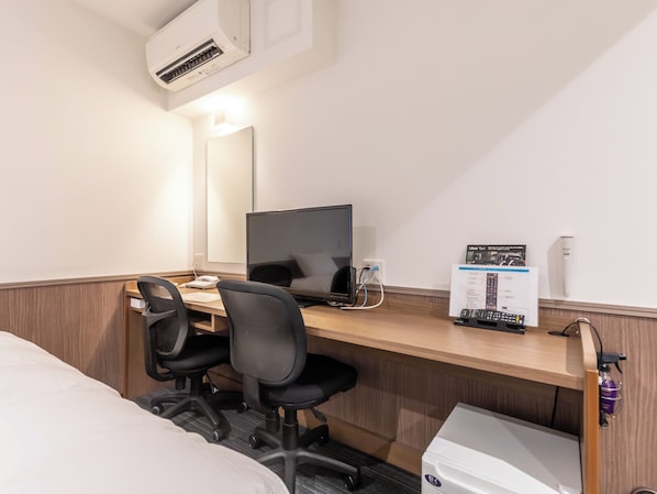 A hotel room with a wooden desk, a computer, a chair, a bed, and a small table with a water bottle. - Hotel Excellence Enmachi Ekimae (Kyoto)
