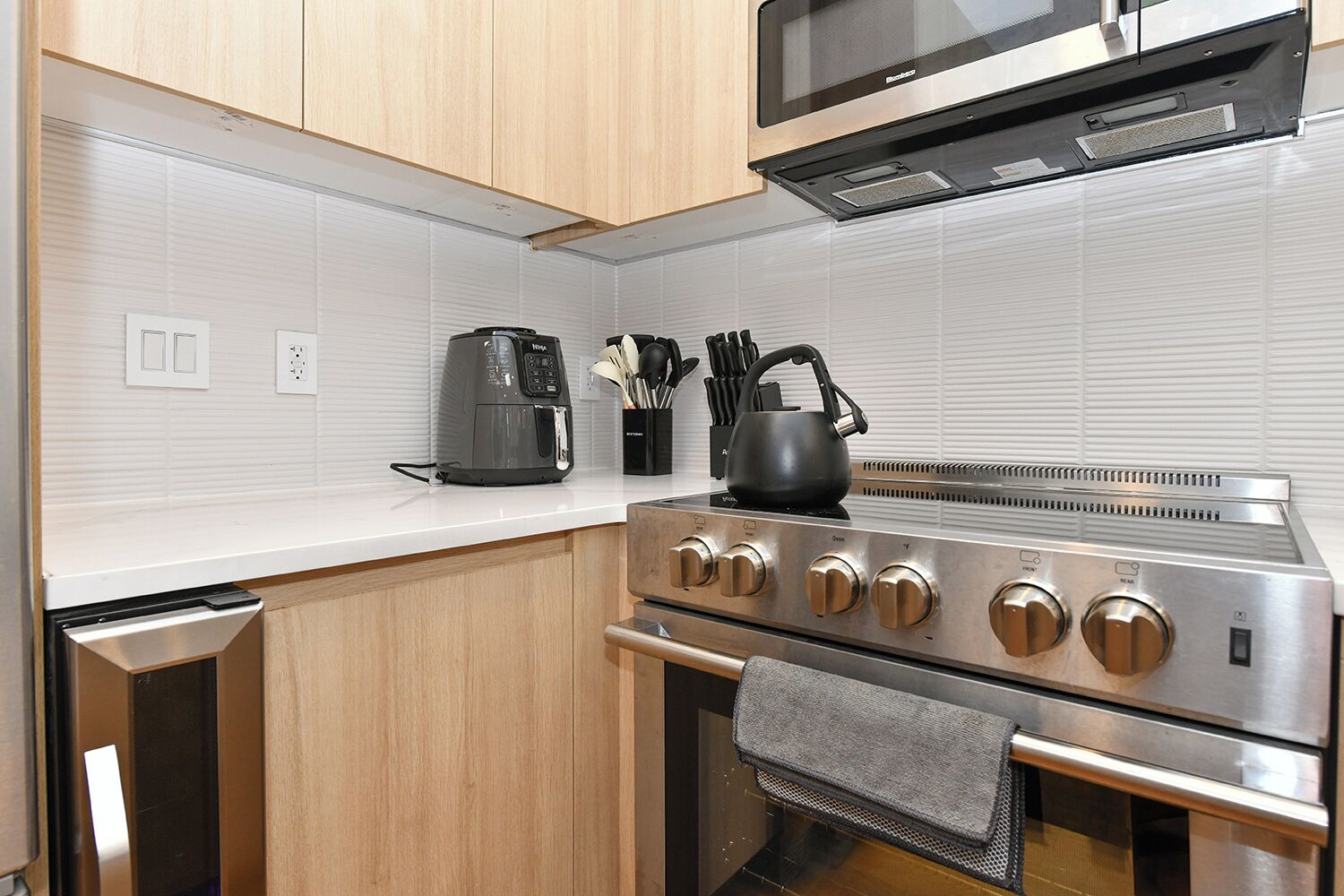 Een praktische keuken met een roestvrijstalen fornuis, een magnetron en een koffiezetapparaat.