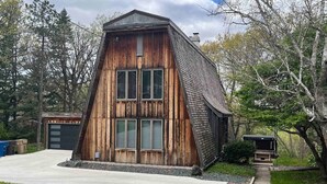 Ein rustikales Holzgebäude mit Satteldach, einer Garage und einem Weg dorthin.