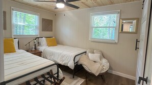 A compact bedroom with two beds, a ceiling fan, and two windows with blinds. - Waubee Lake Remodeled Cozy Cottage on ATV Trails (Lakewood)