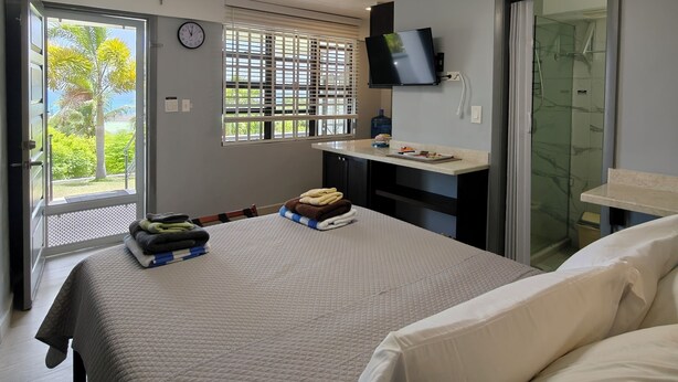 Ein Hotelzimmer mit Bett, Schreibtisch, Fernseher und Dusche.