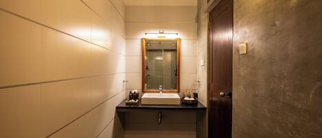 Ein kleines Badezimmer mit Waschbecken, Spiegel und Handtuchhalter.