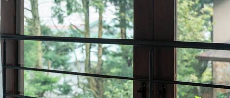 A window with a view of greenery and a wooden structure outside.