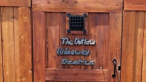 A wooden gate with a sign reading "317½ B" and "The Outlaw Hideaway Downtown". - Outlaw Hideaway Downtown (Prescott)