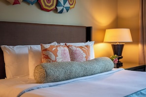 A neatly made bed with floral pillows, a textured throw, and a lamp on a bedside table. - 2 Honua Kai Villas | Ocean View | Sleeps 14 | Free Car w/ 6+ Nights | ML-1285 (Lahaina)