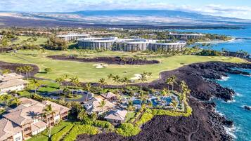 A resort with multiple buildings, a golf course, and a coastline.
