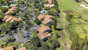 Vue aérienne d’un quartier résidentiel avec des maisons, une piscine et un terrain de golf.