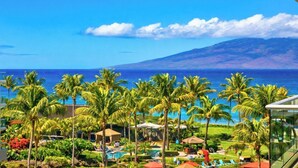 A resort with a pool, palm trees, and a view of the ocean. - Honua Kai | Ocean View 4 BR, Sleeps 14 | Car Incl. w/ 6+ Nights | HKK ML-1305 by KBM (Lahaina)
