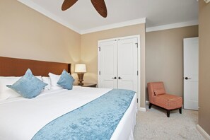 Ein Hotelzimmer mit Bett, Nachttisch mit Lampe, Stuhl und Kleiderschrank.