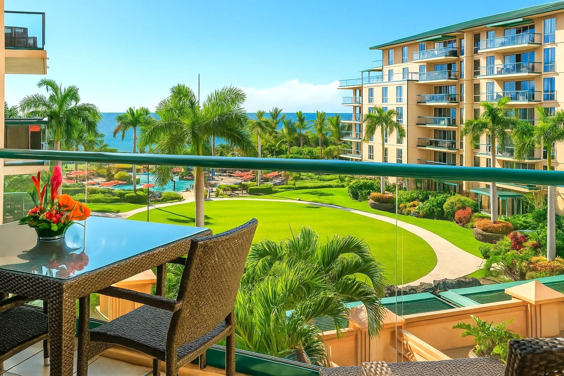 Un balcón con vistas a una piscina, palmeras y un edificio con varios balcones.