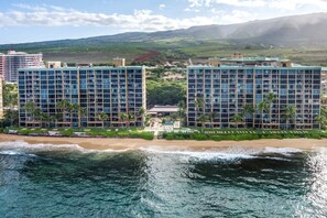 Ein Strandhotel mit mehreren Hochhäusern, einem Poolbereich und Blick auf den Ozean und die Berge.