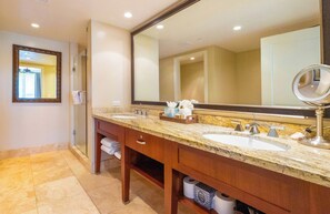 Une salle de bain d’hôtel avec deux lavabos, un grand miroir et un porte-serviettes.