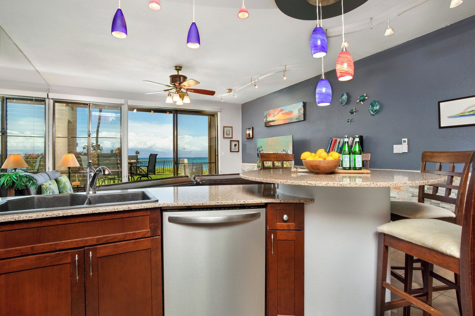 Una cocina con una isla central, lavavajillas y ventilador de techo.