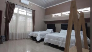 A hotel room with two beds, a wooden ladder, a door, and a window with curtains. - Griya Al Mukmin (Surakarta)