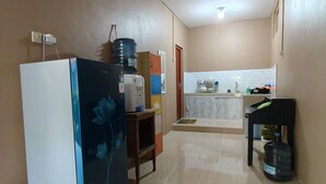 A kitchen with a refrigerator, water dispenser, and a sink. - Griya Al Mukmin (Surakarta)