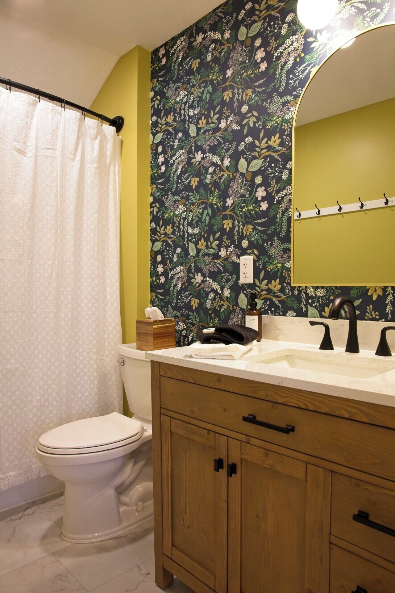 Un baño con inodoro, lavamanos con espejo y cortina de ducha.