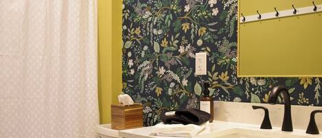 Un baño con inodoro, lavamanos con espejo y cortina de ducha.