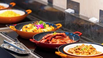 A buffet table with various dishes in colorful serving dishes.