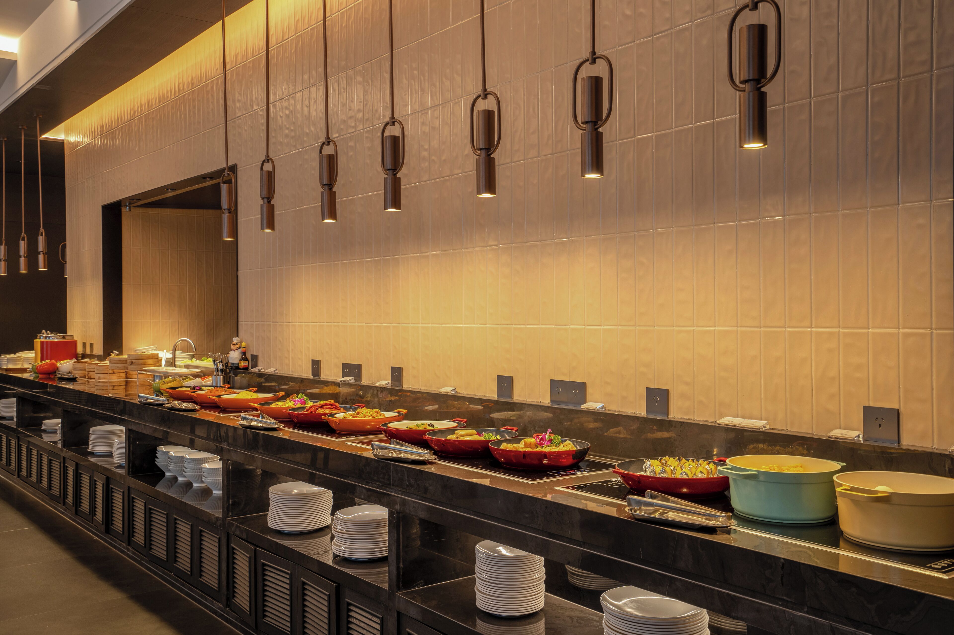 A buffet setup with various food items and stacked plates.