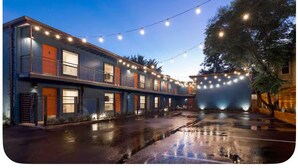 A building with a row of rooms, a wet parking lot, and string lights. - ‘Señorita Sunset’ Guest Fave! Chic Studio Montrose Walkable area! (Houston)