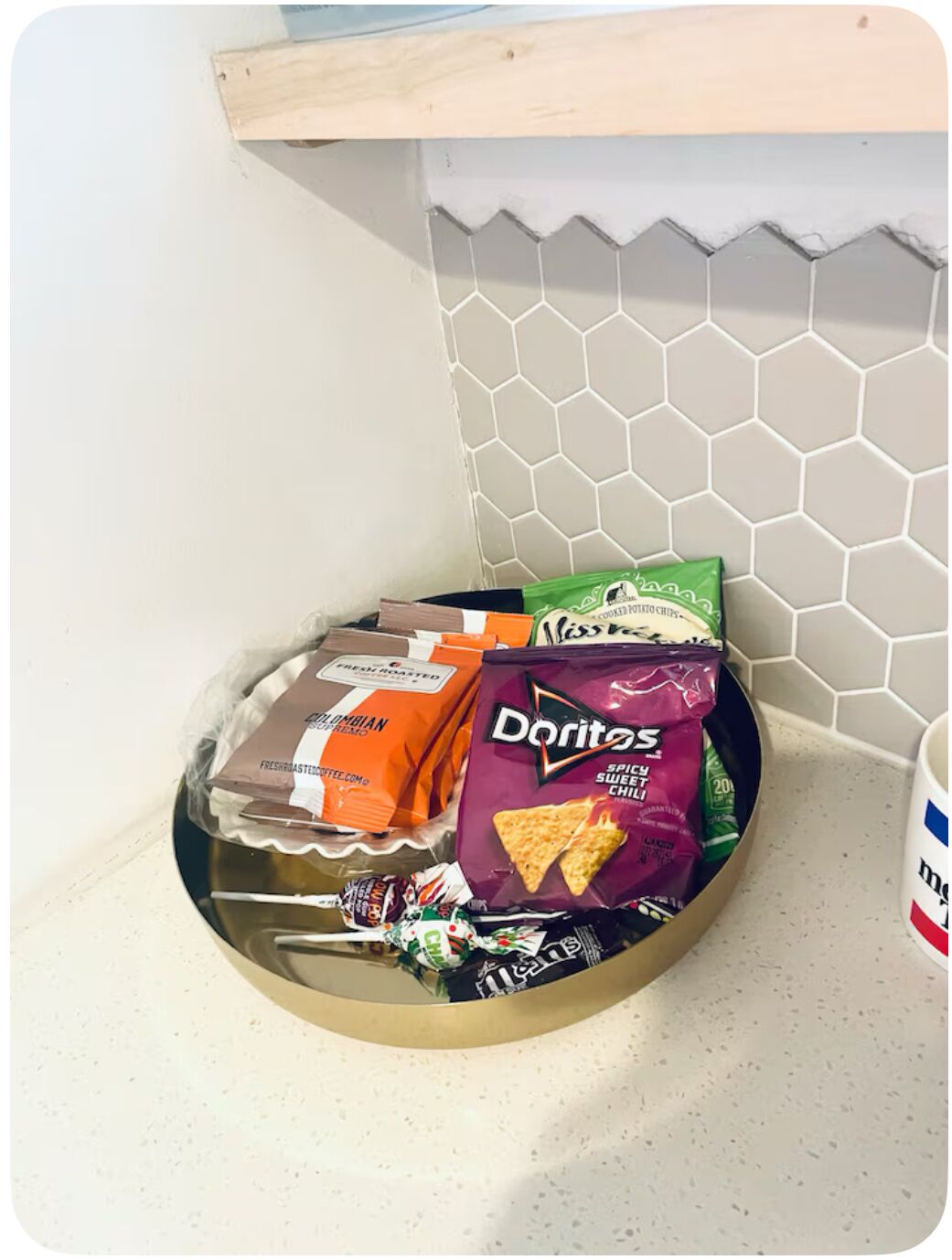A kitchen counter with a variety of snacks including chips and cookies.