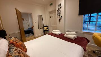 2 habitaciones, escritorio y tabla de planchar con plancha