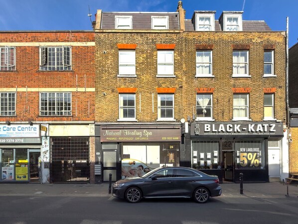 A street view with a row of buildings, including a massage spa and a property management office.