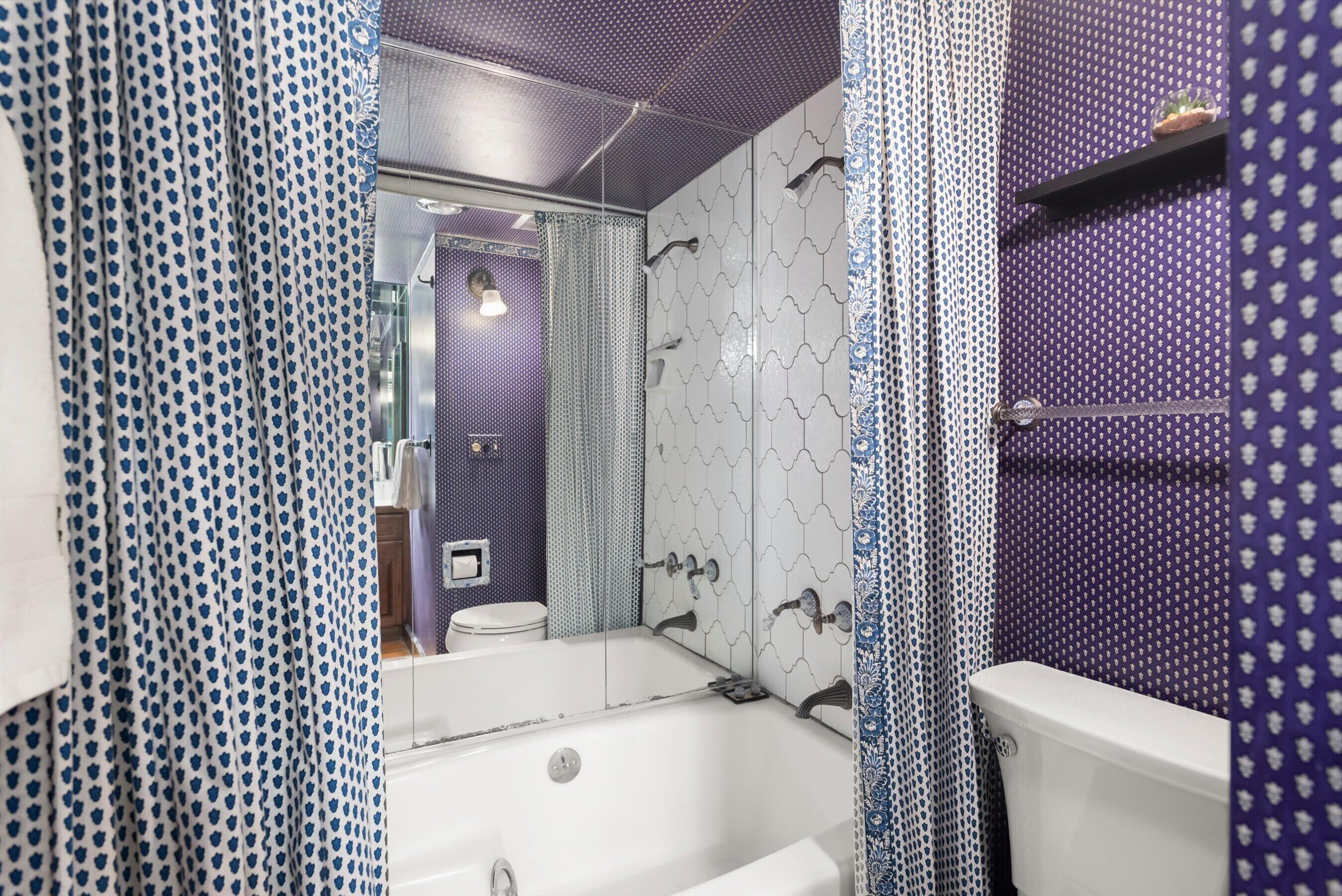 Un baño con bañera, inodoro y zona de ducha.