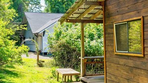 A wooden cabin with a covered porch and a small table. - Artist's farm house children loft m/s Redmond, Seattle (Duvall)