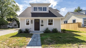 A single-story house with a dark roof, white siding, and a front porch. - Walk Everywhere From Eastport Cape Cod with Gourmet Kitchen (Annapolis)
