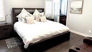 A bedroom with a large bed, a bedside table, a chair, a door, and a window. - Mountain View • Pool House • BBQ (Chino Hills)