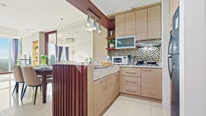 Een moderne keuken met houten kastjes, een ingebouwde magnetron en een grote koelkast.